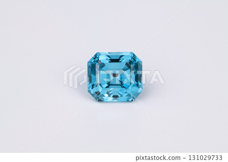 A blue gemstone sits on a white background 131029733