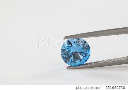 A blue diamond is being held in a metal clamp 131029738