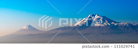 A mountain range with two peaks and a blue sky 131029741