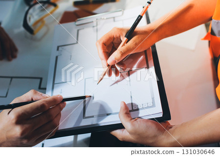 Closeup of team of industrial engineers meeting analyze machinery blueprints consult project on table in manufacturing factory. Working in manufacturing plant or production plant. 131030646