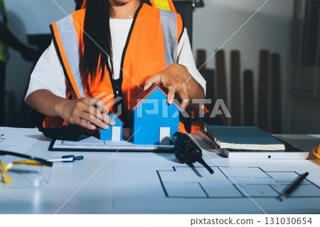 Closeup of team of industrial engineers meeting analyze machinery blueprints consult project on table in manufacturing factory. Working in manufacturing plant or production plant. Closeup of team of industrial engineers meeting analyze machinery blueprints consult project on table in manufacturing factory. Working in manufacturing plant or production plant. 131030654