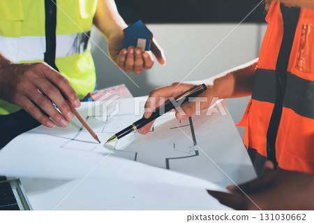 Closeup of team of industrial engineers meeting analyze machinery blueprints consult project on table in manufacturing factory. Working in manufacturing plant or production plant. Closeup of team of industrial engineers meeting analyze machinery blueprints consult project on table in manufacturing factory. Working in manufacturing plant or production plant. 131030662