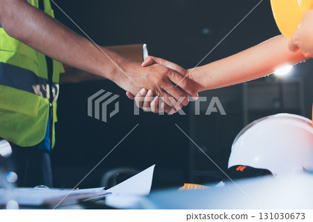 Closeup of team of industrial engineers meeting analyze machinery blueprints consult project on table in manufacturing factory. Working in manufacturing plant or production plant. 131030673