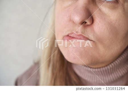 close up of mature caucasian female with neutral expression wearing turtleneck 131031264