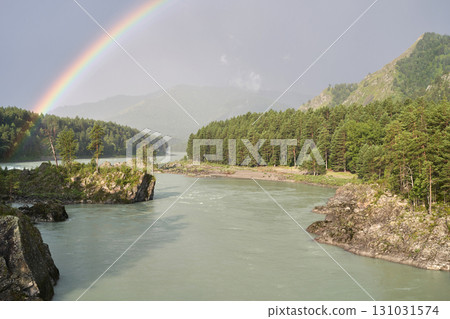 Scenic river with rainbow and forested mountains under a clear sky Scenic river with rainbow and forested mountains under a clear sky 131031574