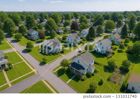 Sunny suburban neighborhood with lush green lawns and modern houses on a clear day. concept of peaceful living, residential community, tranquil environment 131031740
