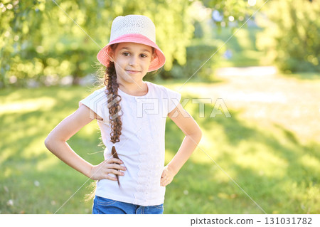 Smiling caucasian young girl in sun hat enjoying sunny day outdoors in park 131031782