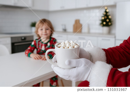 Santa claus holding hot chocolate with marshmallows in cozy kitchen featuring child in christmas pajamas. concept of holiday warmth, festive tradition, seasonal joy. 131031987