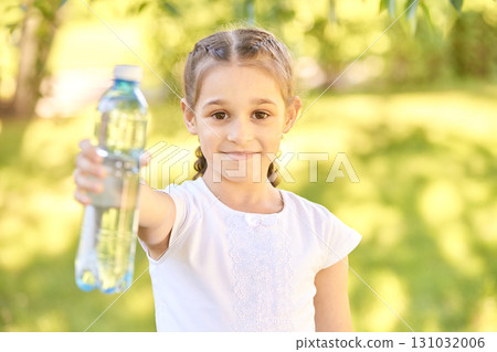 Young caucasian girl holding water bottle outdoors on a sunny day 131032006