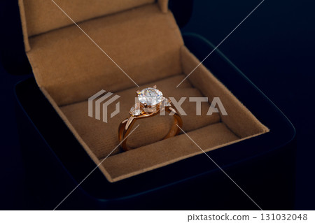 A gold and diamond ring is in a box 131032048