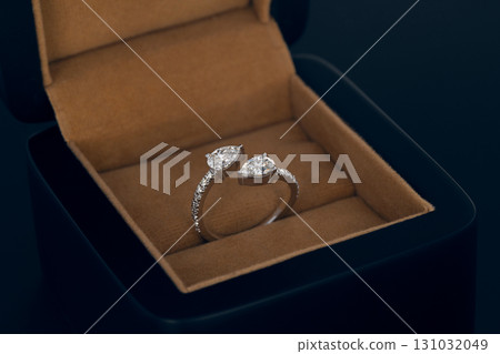 A ring with two diamonds in it is in a box 131032049