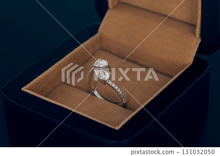 A ring is in a box with a brown background 131032050