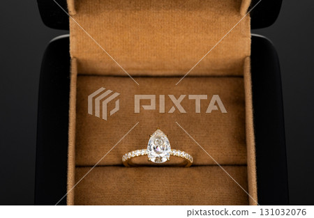 A gold and diamond ring is in a box 131032076