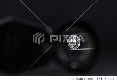 A diamond is being examined under a magnifying glass 131032083