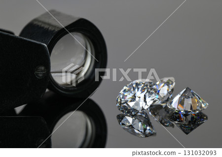A magnifying glass is used to look at three diamonds 131032093