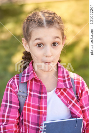 Caucasian young girl with backpack surprised expression holding notebook Caucasian young girl with backpack surprised expression holding notebook 131032264