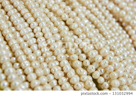 Close-up of shiny white pearls in various sizes showcasing smooth texture 131032994