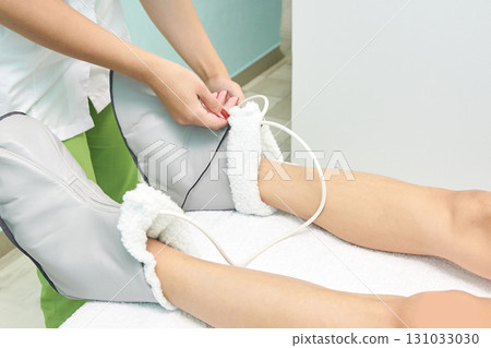 Young caucasian female in spa receiving heat therapy on legs for relaxation Young caucasian female in spa receiving heat therapy on legs for relaxation 131033030