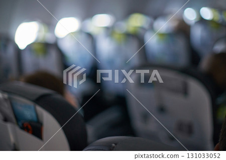 Blurred airplane cabin with passengers and row of seats in flight 131033052