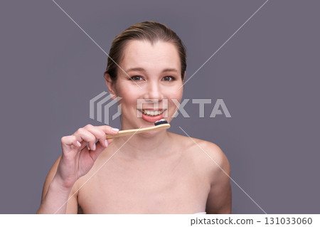 Caucasian young female brushing teeth with bamboo toothbrush smiling healthy Caucasian young female brushing teeth with bamboo toothbrush smiling healthy 131033060