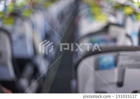 Blurred airplane interior focus on passenger seats with modern design and bright Blurred airplane interior focus on passenger seats with modern design and bright 131033117