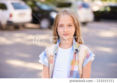 Blonde caucasian young girl with long hair wearing colorful shirt standing 131033151