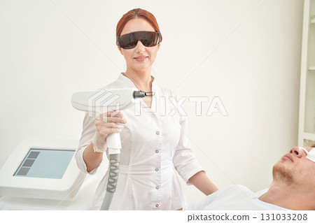 Female asian adult using laser equipment for male patient treatment in modern 131033208