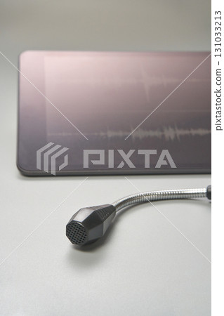 Microphone with tablet displaying sound waveforms on gray surface Microphone with tablet displaying sound waveforms on gray surface 131033213