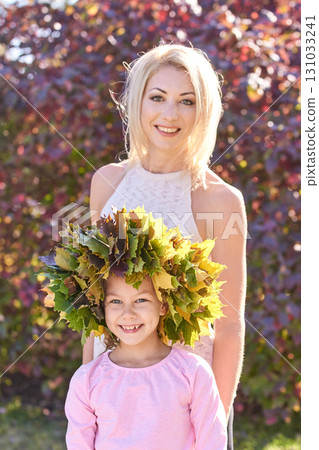 Caucasian female adult with child in autumn leaves, smiling outdoors, sunny Caucasian female adult with child in autumn leaves, smiling outdoors, sunny 131033241