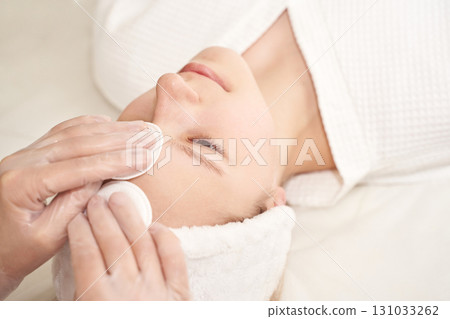 Young caucasian female receiving skincare facial treatment in a spa setting Young caucasian female receiving skincare facial treatment in a spa setting 131033262