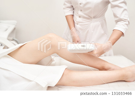 Female laser hair removal session with professional in clinic setting 131033466