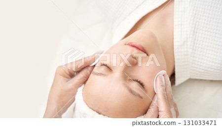Young caucasian female receiving spa facial treatment with relaxing massage 131033471