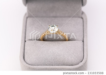 A gold and white diamond ring is in a box 131033508