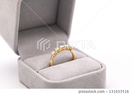 A gold and diamond ring is in a box A gold and diamond ring is in a box 131033516