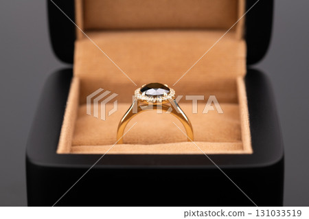 A gold and black ring with a diamond in the center 131033519