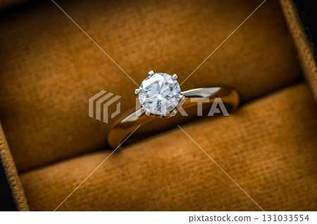 A gold and diamond ring is displayed in a box 131033554