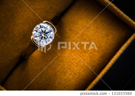 A gold and diamond ring is displayed in a box 131033560