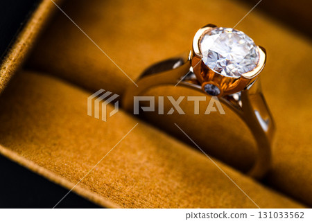 A gold and diamond ring is sitting in a box A gold and diamond ring is sitting in a box 131033562