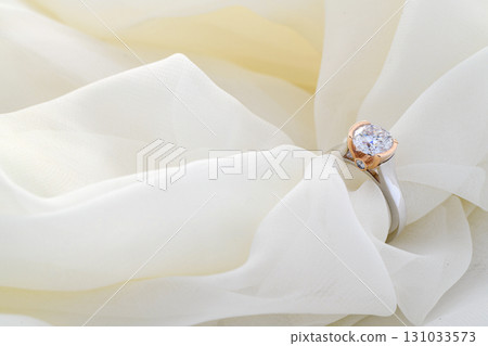 A white cloth with a diamond ring on it 131033573