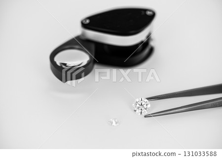 A diamond is being examined by a jeweler using a magnifying glass 131033588