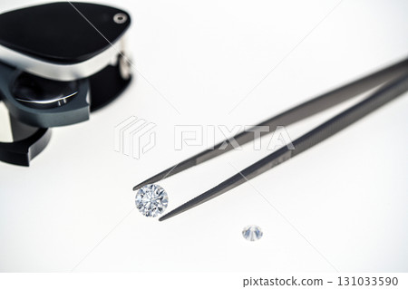 A diamond is being examined by a jeweler using a magnifying glass A diamond is being examined by a jeweler using a magnifying glass 131033590