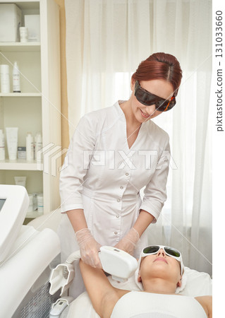 Caucasian female adult receiving laser hair removal from female technician 131033660