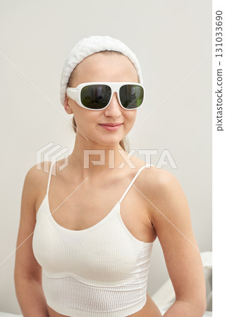 Young caucasian female in spa attire wearing protective goggles in light room 131033690