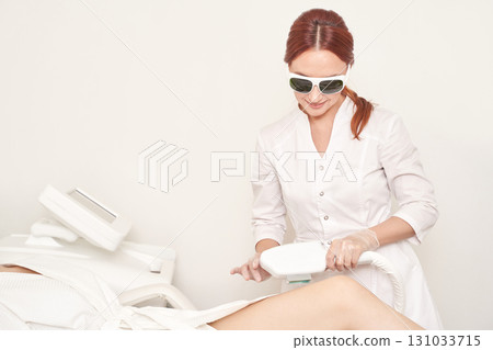 Female technician performing laser hair removal on adult caucasian client Female technician performing laser hair removal on adult caucasian client 131033715