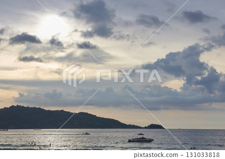 Scenic coastal landscape with cloudy sky, island, and boat on calm ocean waters Scenic coastal landscape with cloudy sky, island, and boat on calm ocean waters 131033818