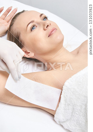 Caucasian female adult receiving armpit waxing in spa salon for hair removal 131033923