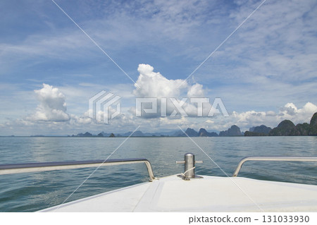 Scenic view from boat of tropical islands under clear blue sky with fluffy Scenic view from boat of tropical islands under clear blue sky with fluffy 131033930