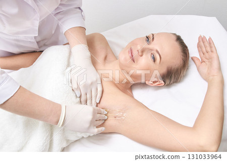 Caucasian female adult receiving professional armpit hair waxing treatment Caucasian female adult receiving professional armpit hair waxing treatment 131033964