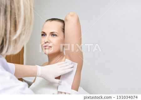Caucasian female adult receiving armpit waxing treatment at beauty salon Caucasian female adult receiving armpit waxing treatment at beauty salon 131034074