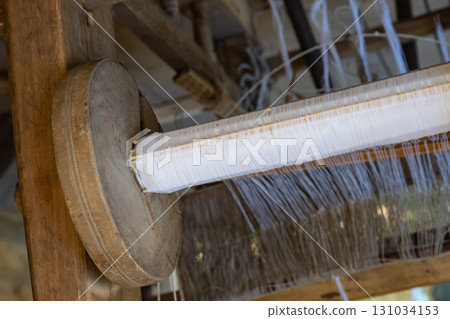 mechanism of a wooden loom with a bobbin of thread close-up, traditional carpet production mechanism of a wooden loom with a bobbin of thread close-up, traditional carpet production 131034153